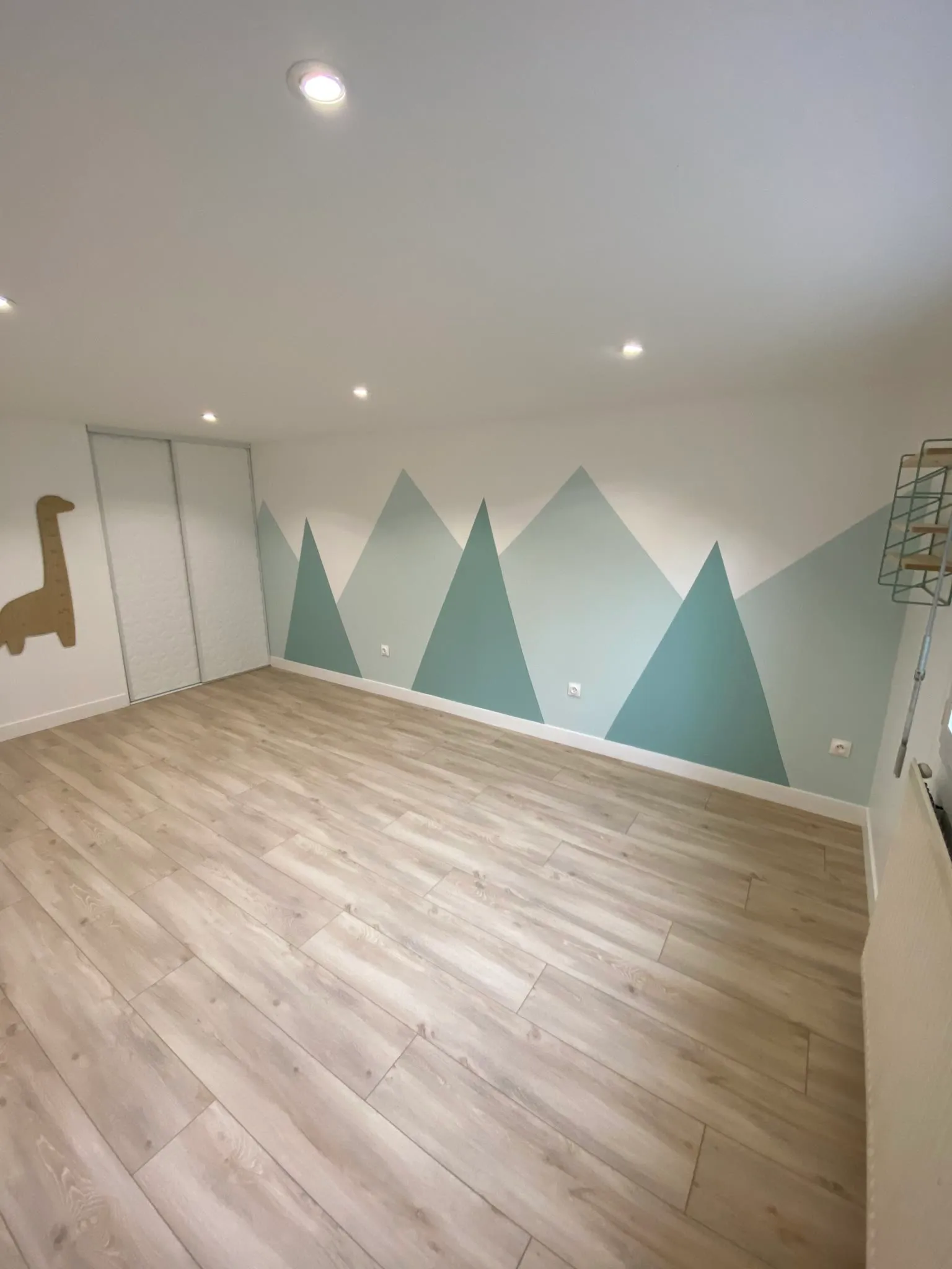 Chambre d'enfant avec fresque murale en forme de montagnes et sol stratifié